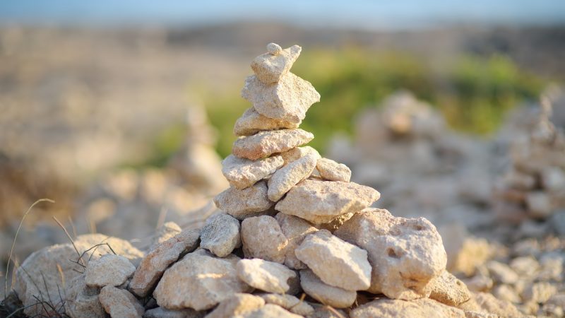cairn-of-stones-in-desert-hills-on-cyprus-pyramid-of-rocks-marking-the-trail-for-hiking-.jpg